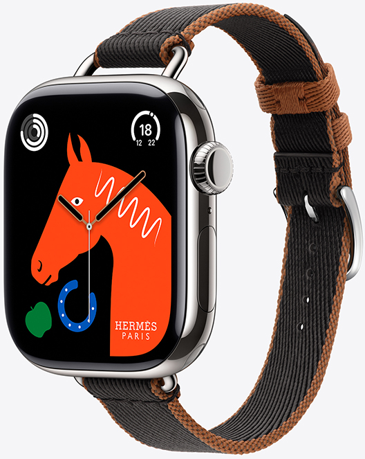 Angled view of the new Twill Jump Attelage Single Tour band in Noir/Gold (black with gold trim) with the 'Lucky Horse' watch face featuring an orange horse's head, a green apple and a blue horseshoe.