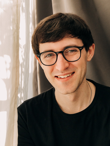 Photo portrait of Matthew, smiling as he looks at the reader.