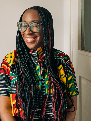 Photo portrait of Shirleena, with a big smile, eyes closed, turned away from the reader.