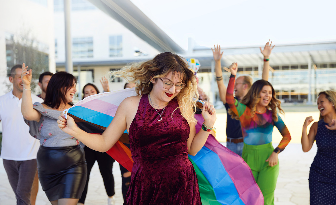 Group of Apple employees dancing and celebrating outside.