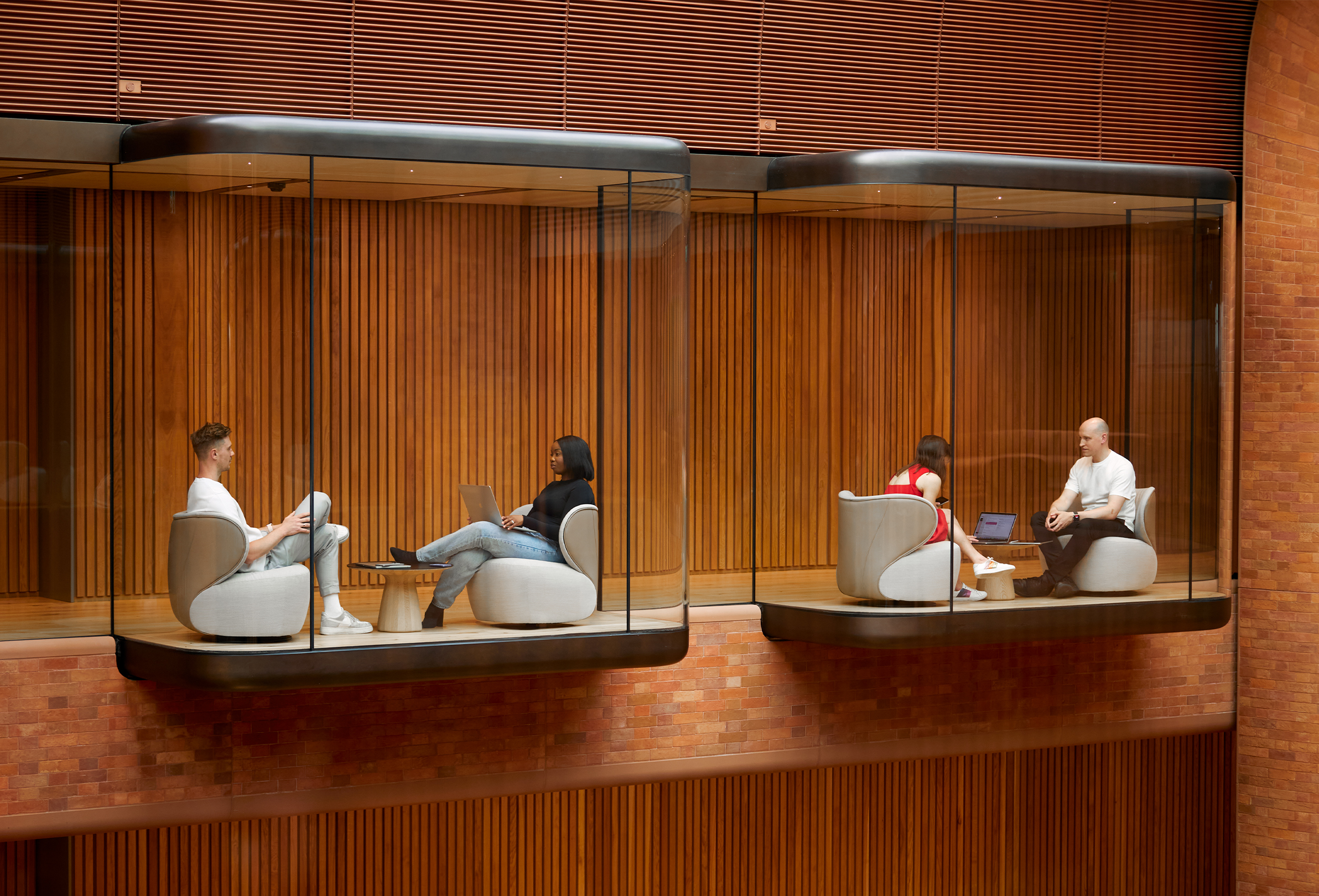 Two pairs of Apple colleagues working in two separate interior bay windows facing the Battersea atrium.