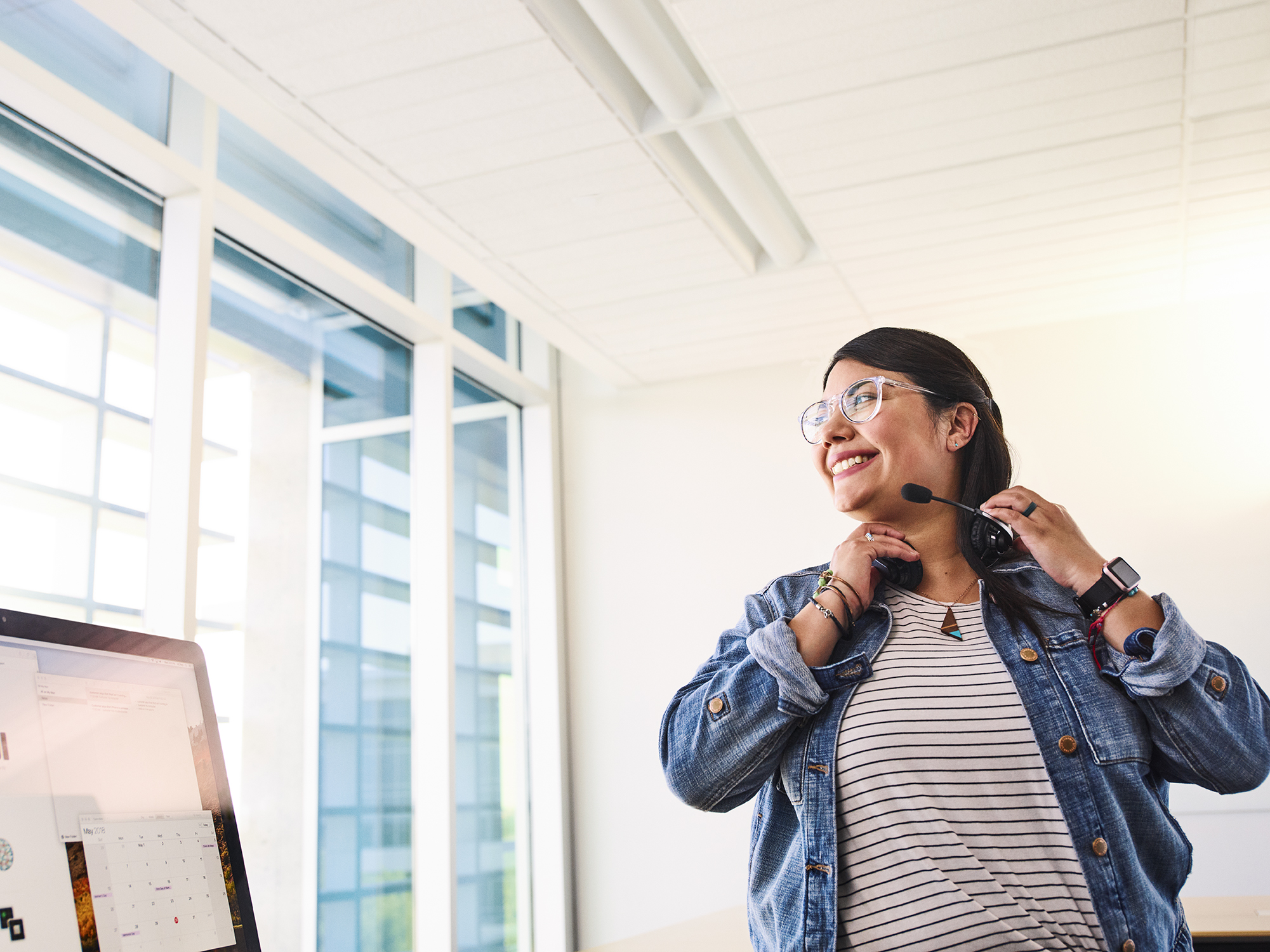 Apple medewerker die met een headset op voor een computer zit.