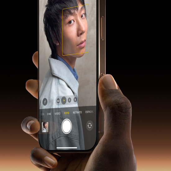 Una mano sostiene un iPhone 16 Pro titanio del desierto, con el pulgar deslizándose por el botón de Control de la Cámara para seleccionar la funcionalidad Foto