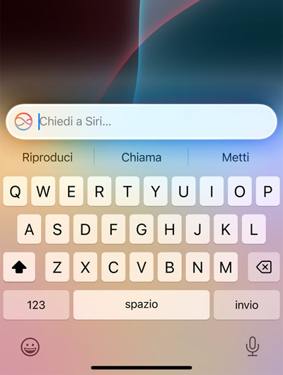 Un campo di testo sopra la tastiera video di un iPhone con la scritta: Chiedi a Siri