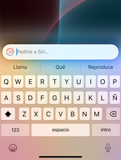Un campo de texto en la parte superior del teclado de un iPhone dice: Pedirle a Siri
