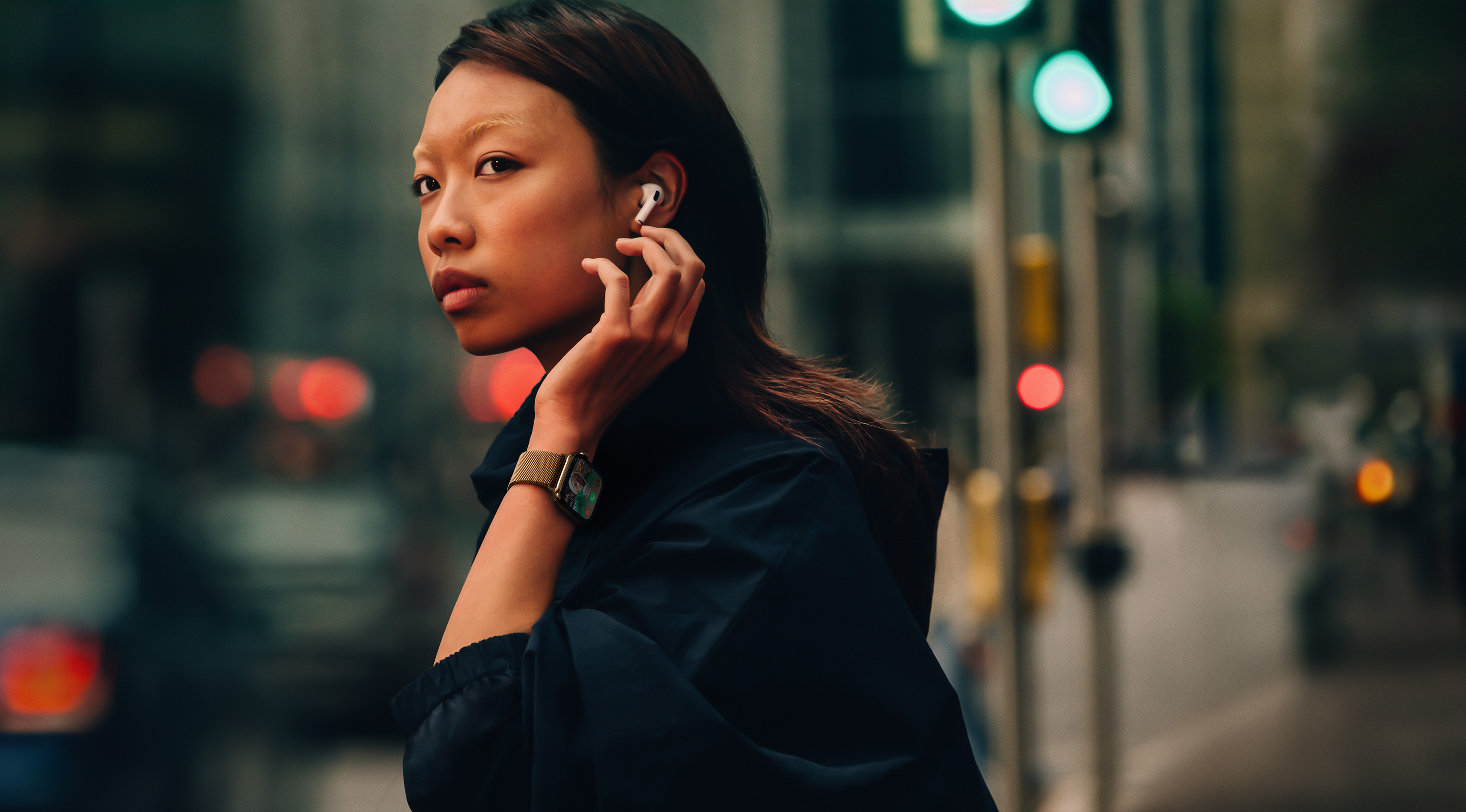 ผู้หญิงคนหนึ่งบนถนนสวมใส่ Apple Watch Series 10 และ AirPods