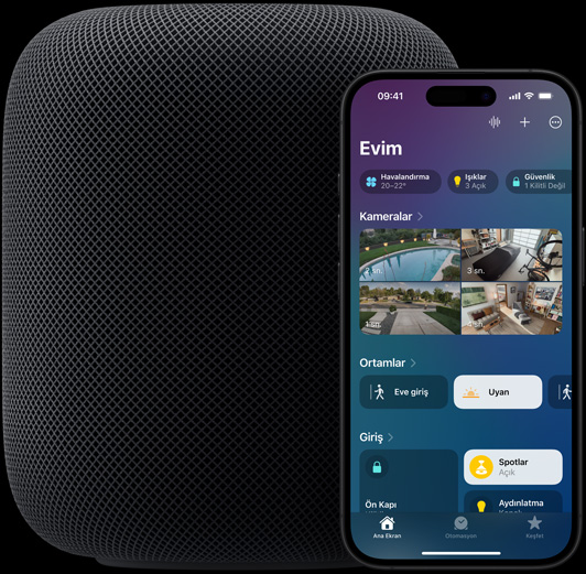 Ekranında, Ev uygulamasının ana ekranının görüldüğü bir iPhone, bir HomePod hoparlörün hafifçe önüne doğru yerleştirilmiş durumda