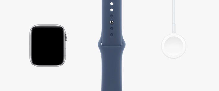 Bredvid varandra: Apple Watch SE framifrån, ett sportband i stjärnglans och magnetisk laddningskabel med usb‑c-kontakt.