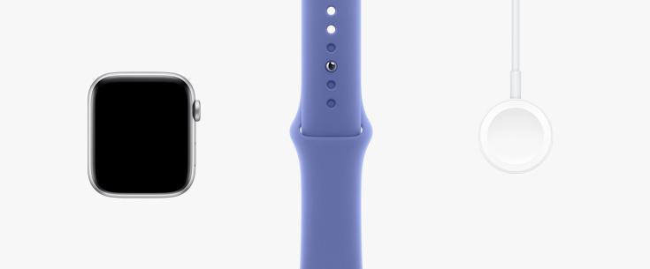 Lined up in a row: front view of Apple Watch SE hardware, a Periwinkle (purple/blue) sport band, and Magnetic Charger to USB-C Cable.