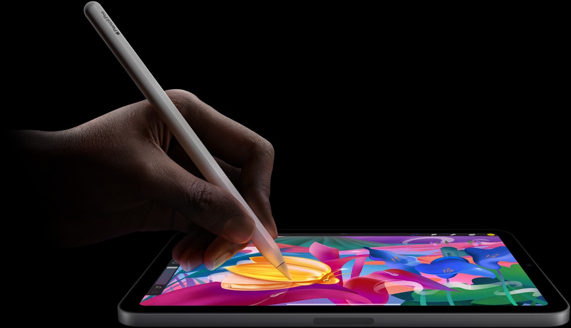 ユーザーがApple Pencil Proを手に持ち、iPad mini上でカラフルなアートワークを作成している。