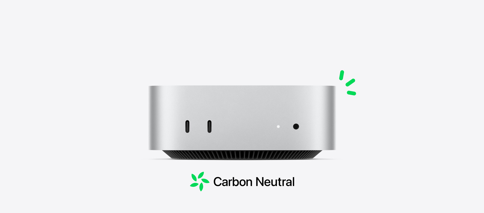 Vue de face d’un Mac mini argent montrant les ports avant, avec de petites illustrations vertes représentant la neutralité carbone. 